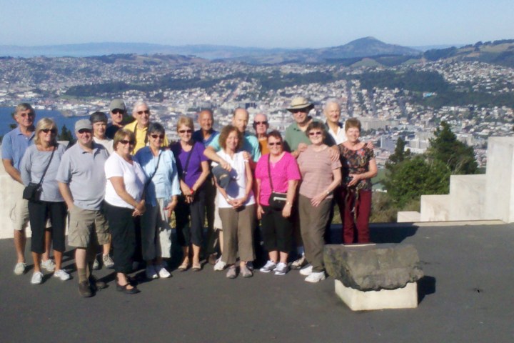 a group of people standing in front of a mountain