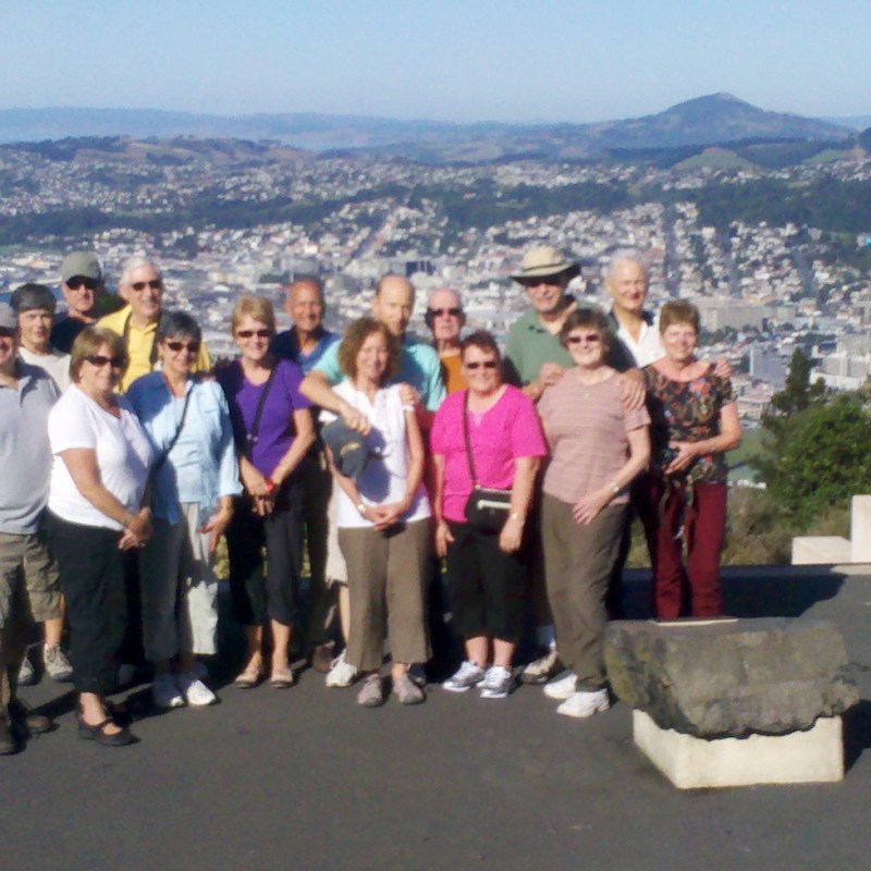 a group of people standing in front of a mountain