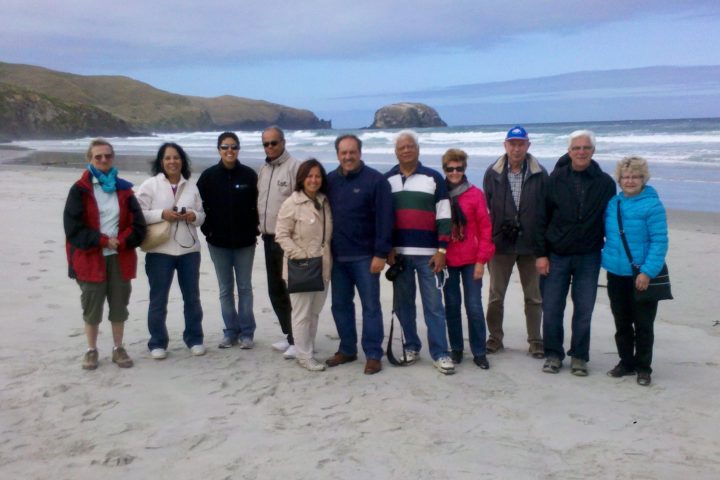a group of people standing on a beach posing for the camera