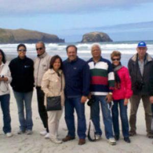 a group of people standing on a beach posing for the camera